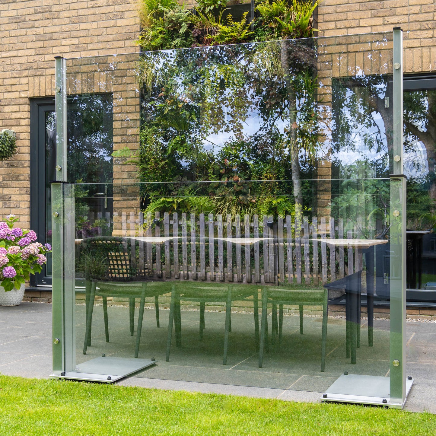 UV blue tinted freestanding glass panel on a patio in front of a dining set