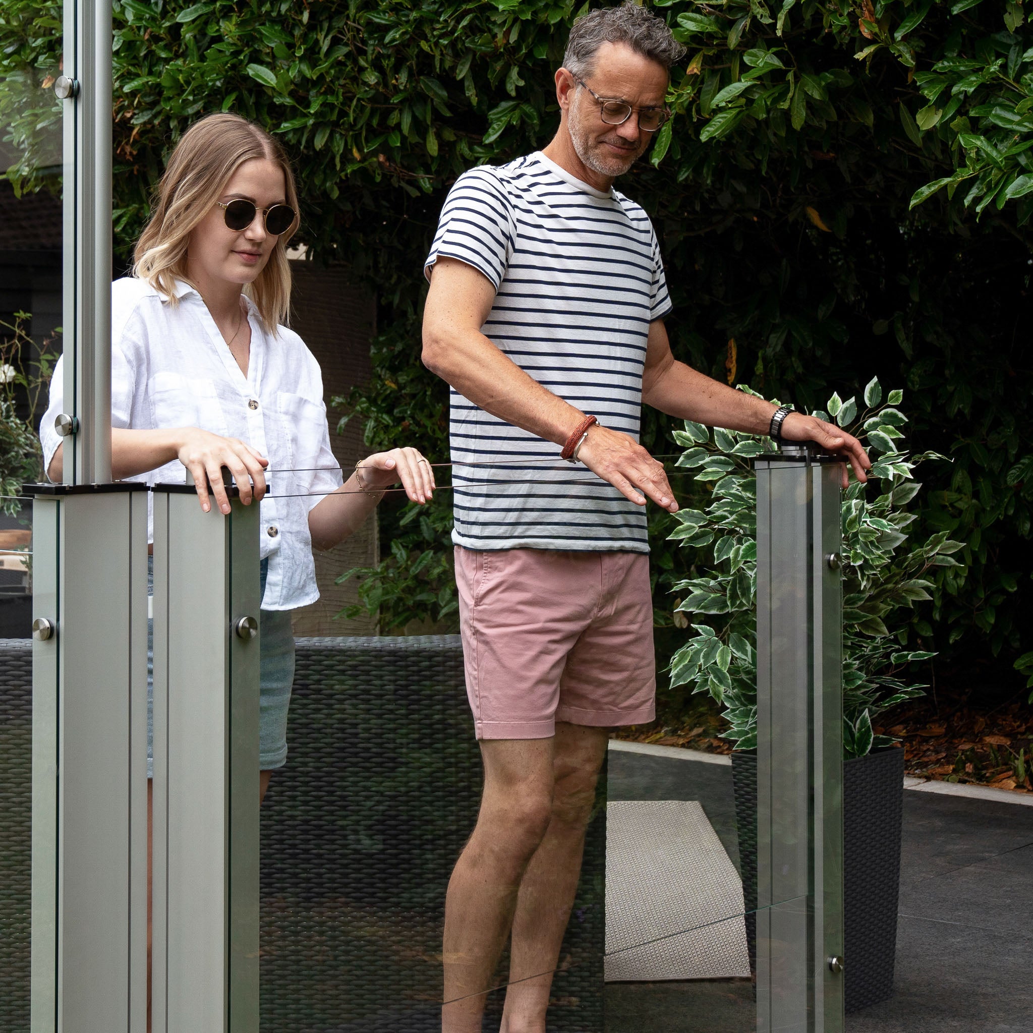 a man and women operating the stopbreeze retractable glass balustrades